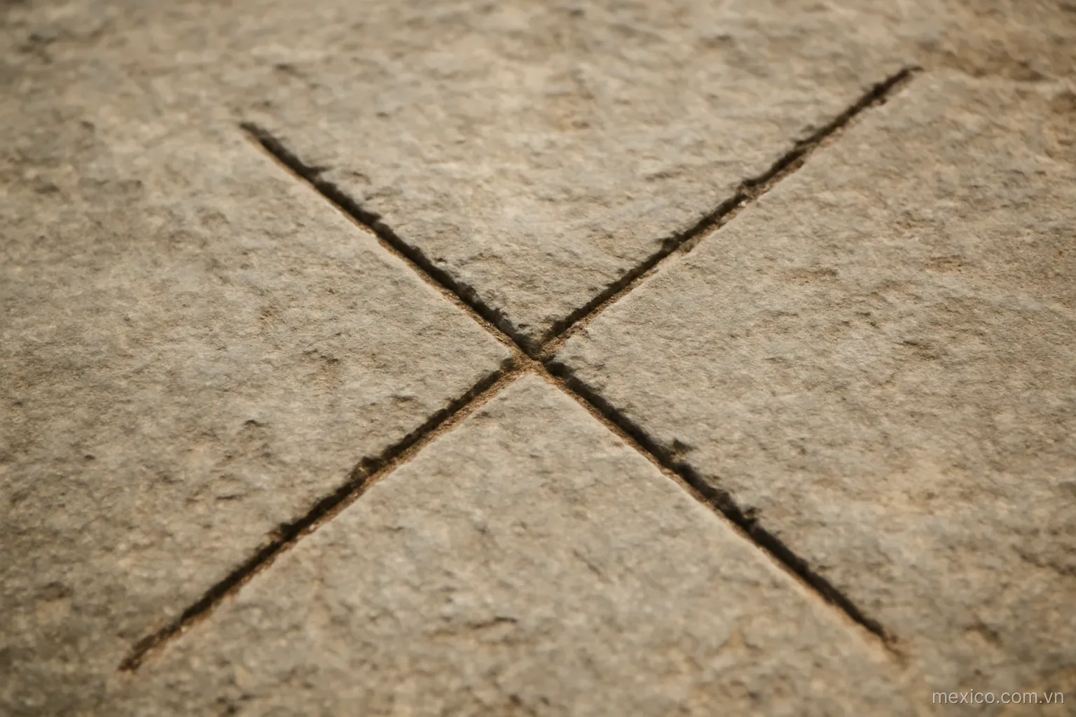 Two grooves crossing at an angle carved into a flat stone slab, overhead view, no text